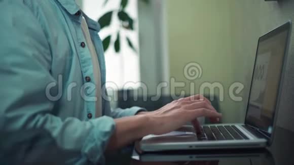 穿着休闲服的年轻人在办公室里用手提电脑喝咖啡视频的预览图