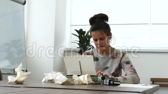 一位年轻的女作家在白屋子里打打字机视频的预览图