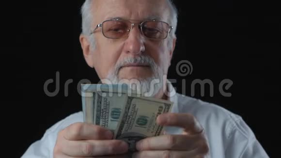 穿白衬衫的老人的肖像数美元钞票视频的预览图