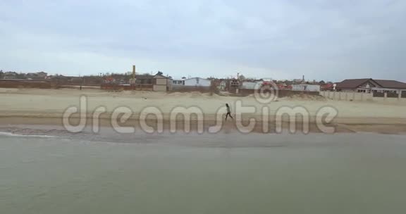 空中观景一名运动男子在乌克兰敖德萨海滩上奔跑视频的预览图