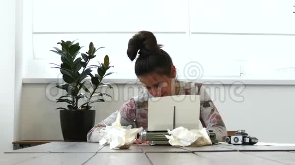 一位年轻的女作家在白屋子里打打字机视频的预览图