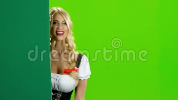 穿着巴伐利亚服装的女孩从黑板上展示拇指啤酒节绿色屏幕视频的预览图
