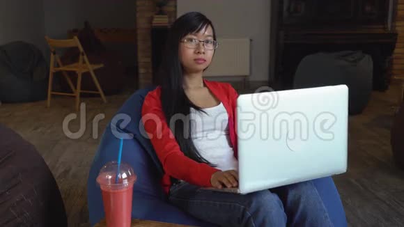 亚洲年轻的职业女性在电脑上工作喝着冰沙视频的预览图