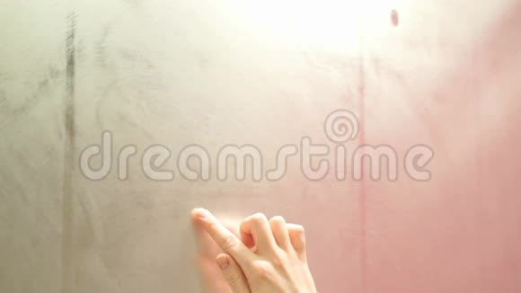 女孩用手指在雾蒙蒙的镜子上快速地画出一颗心视频的预览图