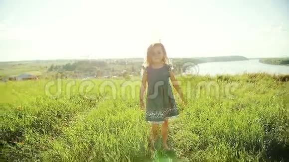 日落时分小女孩在草地上奔跑视频的预览图