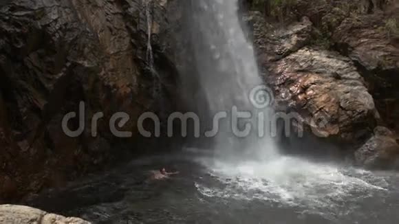 在公园瀑布脚下的河池里游泳视频的预览图