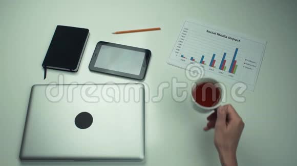 带有办公用品的桌面男人的手放在桌上的一杯茶视频的预览图