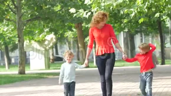 母亲和两个孩子在路上行走视频的预览图