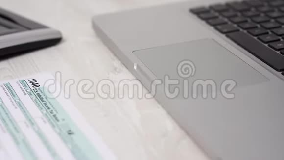 滑车移动射击的税表1040在桌子旁边的电脑笔记本电脑和计算器4k视频视频的预览图