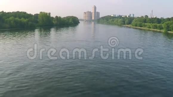 莫斯科河森林睡莲和遥远豪华住宅的空中下降镜头视频的预览图