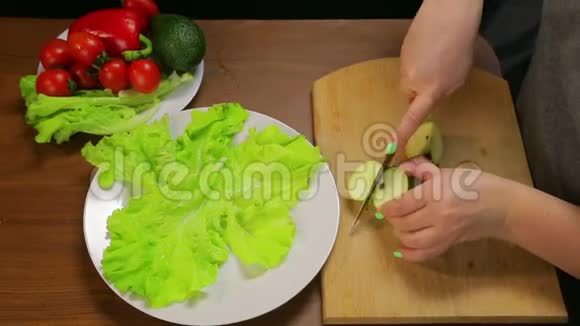 女人在木板上用刀切一个绿苹果视频的预览图