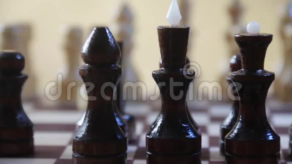 国际象棋骑士与国际象棋骑士在黄金背景上的其他人物盘着旋转镜头对称视频的预览图