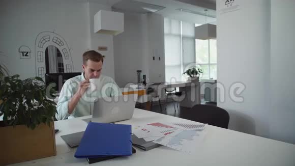 帅哥坐在办公室里和同事聊天视频的预览图