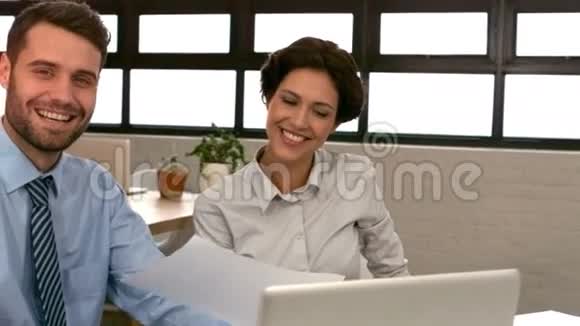 商务夫妇拿着文件对着镜头微笑视频的预览图