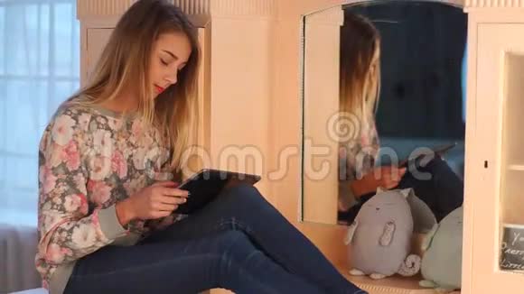 年轻漂亮的少女坐在客厅的马桶上用平板电脑和朋友聊天很有趣视频的预览图