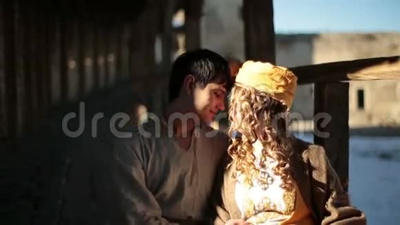 穿着传统服装的浪漫情侣在古老的中世纪城堡里轻轻接吻视频的预览图