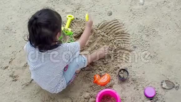 那个小亚洲女孩正在操场上玩沙子玩是一种学习发展为孩子们建立肌肉视频的预览图