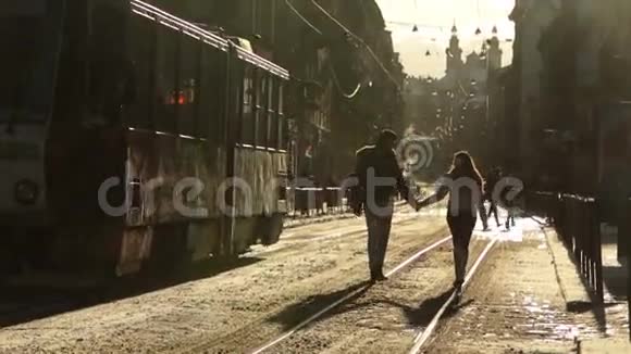 在冬天的早晨美丽快乐时尚的夫妇在欧洲城市的街道上散步和牵手利沃夫市视频的预览图