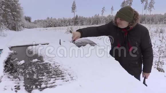 冬天人们从雪地里清理车窗视频的预览图