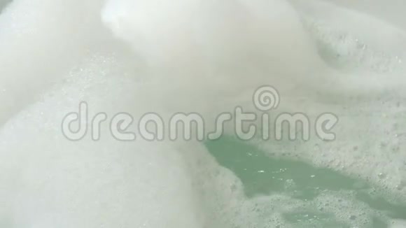 脚女孩躺在泡沫的圆形浴缸里视频的预览图