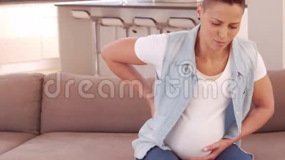 背疼的孕妇站在沙发上视频的预览图
