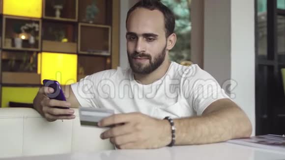 男子使用手机以信用卡进行网上购物视频的预览图