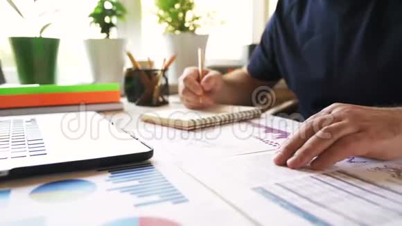 商人分析财务报告并在笔记本上写笔记视频的预览图