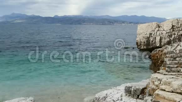 蓝色泻湖海滩海岸卡西奥皮村科孚岛希腊爱奥尼亚海的岩石海岸清澈的绿松石水视频的预览图