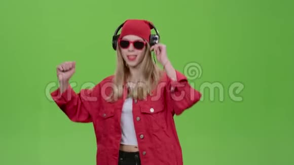 女孩用精力充沛的歌曲在耳机上听音乐绿色屏幕视频的预览图
