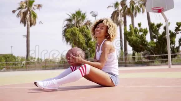 年轻的黑人女运动员在球场上与视频的预览图
