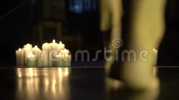 优雅的女人光着腿在黑暗的房间里燃烧着蜡烛视频的预览图