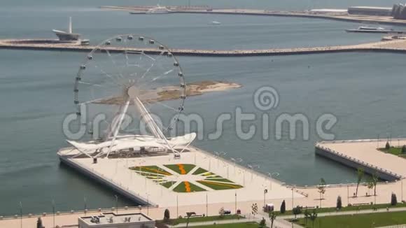 摩天轮在海边旋转路上车辆川流不息全景尽收眼底巴库阿塞拜疆时间推移视频的预览图