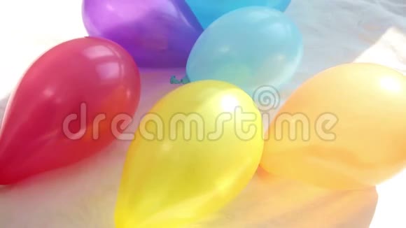 男人和女人的手在床单上用五颜六色的气球吸引心视频的预览图