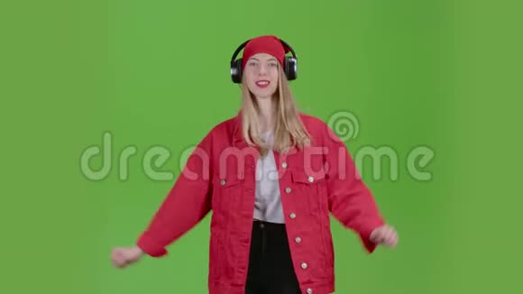 女孩用精力充沛的歌曲在耳机上听音乐绿色屏幕视频的预览图