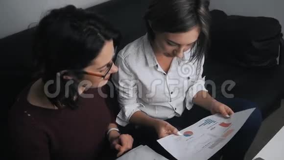 由两名女性组成的业务团队负责处理文档讨论财务结果和分析统计数据视频的预览图