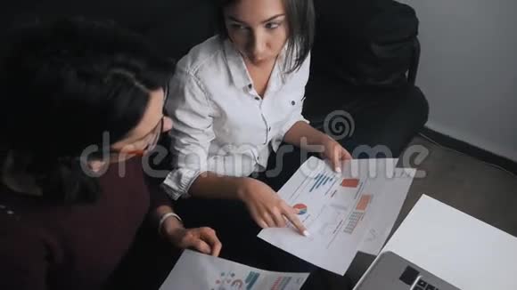 由两名女性组成的业务团队负责处理文档讨论财务结果和分析统计数据视频的预览图