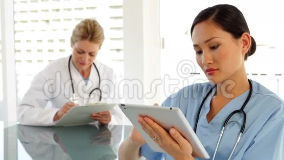 坐在办公桌前用平板电脑的医务工作者视频的预览图