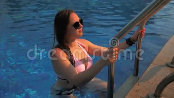 漂亮的女孩从游泳池里出来夏日的阳光慢动作视频的预览图