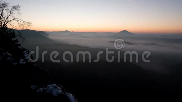时光流逝冰冻秋日的黎明岩石上覆盖着新鲜的粉末雪石岩峰由雾谷增加视频的预览图