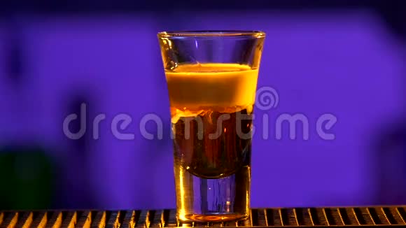 酒吧服务员继续用特殊设备将鸡尾酒倒入玻璃杯中搅拌射击慢动作视频的预览图
