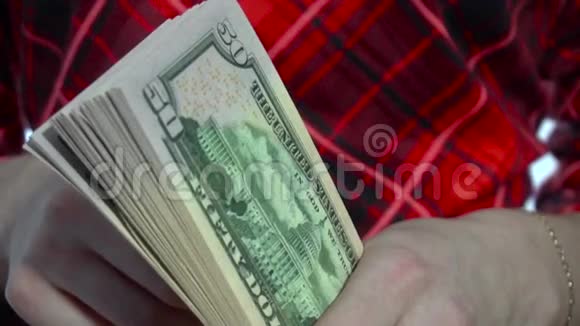 一个穿着红色衣服的年轻女子手里拿着一包钱动作很慢视频的预览图