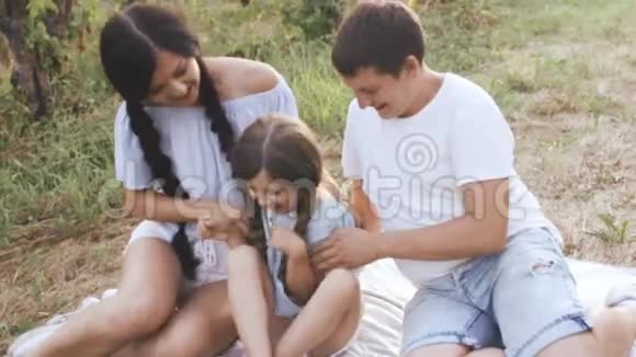 父母在大自然中逗笑的女孩视频的预览图