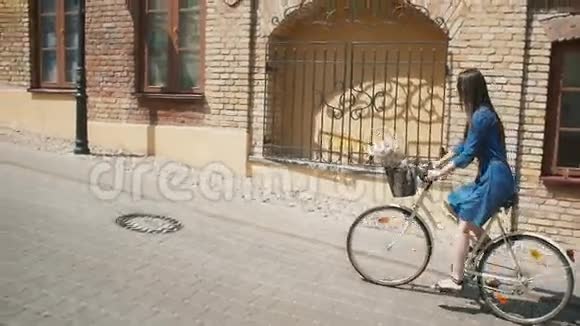 从侧面看一个女孩骑着花篮在路上在城市里探险慢的稳定的镜头视频的预览图