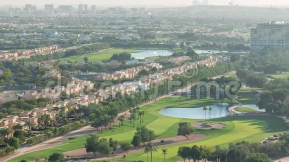 带绿色草坪和湖泊的高尔夫球场的别墅和房屋的空中景观视频的预览图