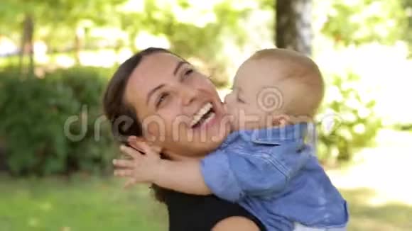 夏天一位年轻快乐的母亲和她刚出生的儿子在公园里散步视频的预览图