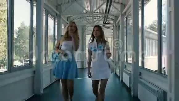 两个女孩穿过长长的走廊视频的预览图