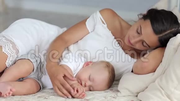 妈妈和她刚出生的婴儿正睡在卧室的床上肖像视频的预览图