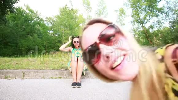 两个年轻女子笑着摆姿势拍照视频的预览图