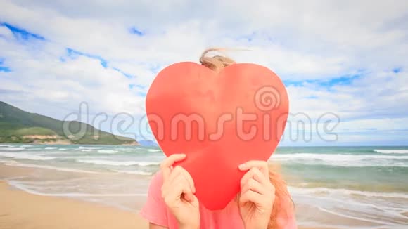 大红心男人背后的女孩出现在海滩上接吻视频的预览图