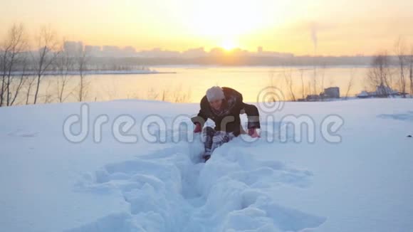快乐快乐的女人在户外玩在冬天把雪扔到相机上在神奇的时候雪的自然会慢动作视频的预览图